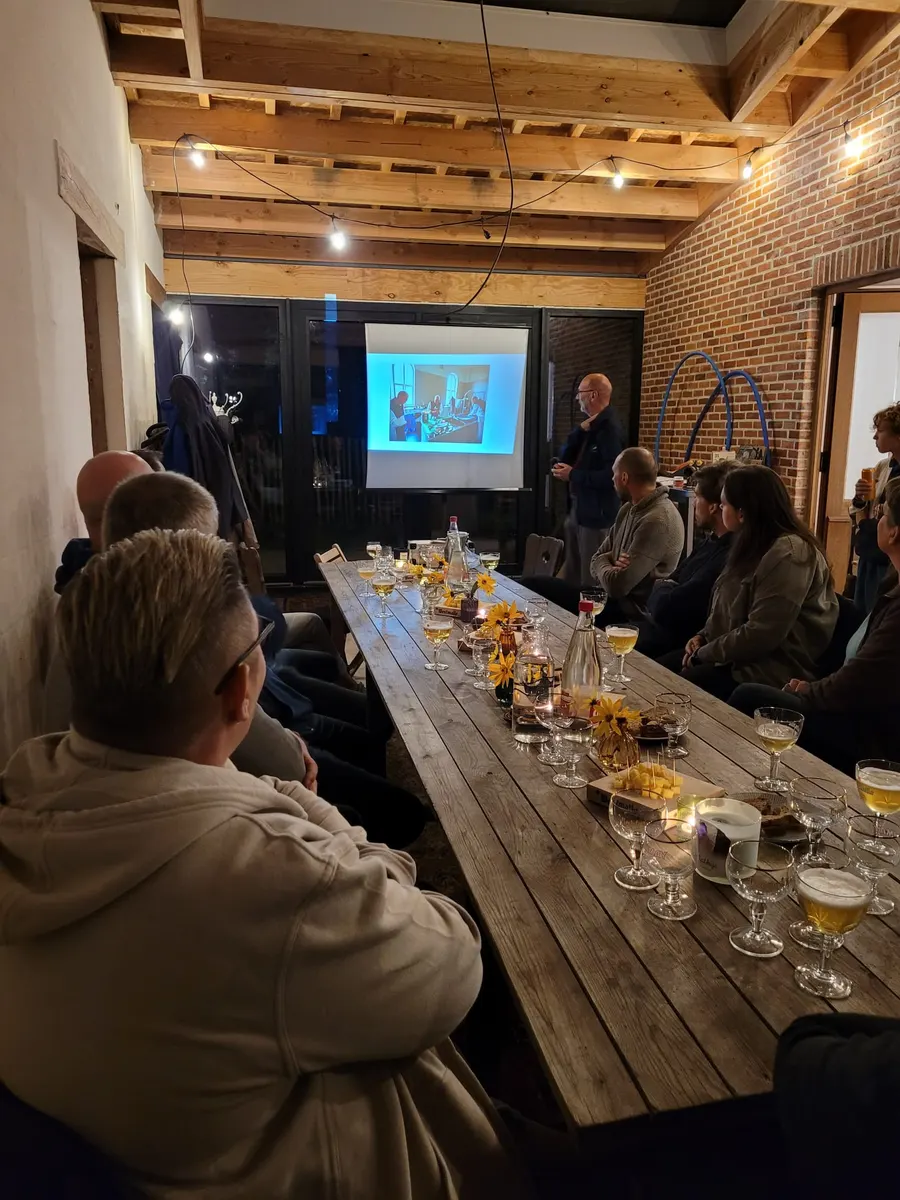 Een lange tafel met proefglazen tijdens een presentatie